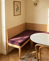 Plum velvet L-shaped cushion on a banquette with a marble table