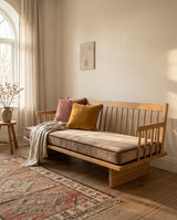 Beige velvet seat cushion on a wooden spindle sofa