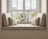 Taupe window seat cushion with angled side backrests below a city window