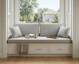 Gray seat and back cushions on a white window seat with drawers