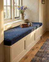 Navy boucle cushion on a white window seat with drawers