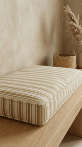Tan striped box cushion on a light oak bench