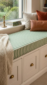 Green striped cushion on a white window seat with drawers