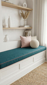 Teal cushion with contrast piping on a white window bench