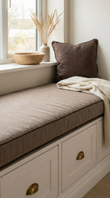 Taupe cushion with dark piping on a white window seat with drawers