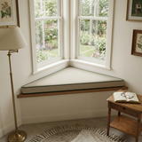 Cream triangle cushion on a corner window seat in a reading nook