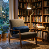 Navy blue bolster cushion on a brown armchair in a home library