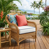 Coral and tropical-print throw pillows on a wicker armchair on a deck