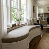 Taupe kidney-shaped cushion on a curved bay window seat