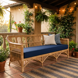 Navy blue cushion on a rattan bench on a lantern-lit terrace