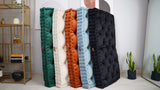 Five velvet tufted floor cushions standing upright against a wall