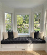 Charcoal tufted trapezoid cushion on a white bay window seat