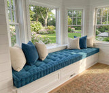 Teal tufted corduroy cushion on a long bay window seat