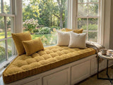 Mustard tufted corduroy trapezoid cushion on a white bay window seat