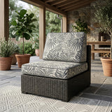 Gray palm-leaf print outdoor cushions on an armless wicker chair