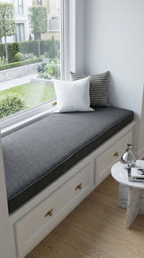 Charcoal cushion on a white window seat facing a garden