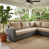 Tan cushions on a gray wicker sectional on a covered porch