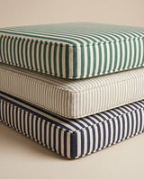 Stacked striped cushions in green, beige and navy