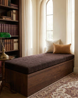 Dark brown chenille cushion on a walnut storage bench