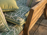 Close-up of green geometric cushions on a wooden bench