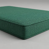 Close-up of a green woven outdoor cushion corner with piping