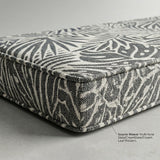 Charcoal and cream leaf-print outdoor cushion corner with a fabric label
