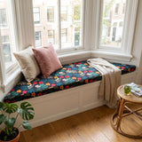 Teal floral print cushion on a bay window bench with pink pillows