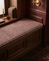 Burgundy point weave cushion on a dark wood window bench