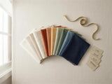 Fan of Foamera fabric swatches in neutral, warm and blue tones with labels and a ribbon