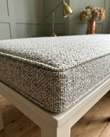 Close-up of a gray textured cushion edge with piping
