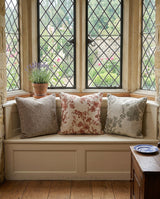 Three blossom pillows on a window seat with leaded windows