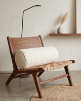 Cream textured bolster pillow on a wooden sling chair