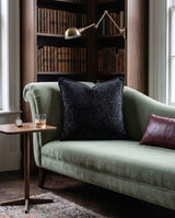 Black textured pillow on a sage chaise lounge
