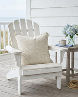 Oatmeal pillow on a white Adirondack chair on a porch
