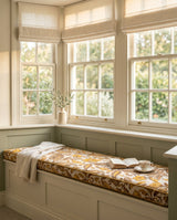 Gold paisley cushion on a green-painted bay window seat