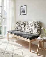 Black and white floral back cushions on a charcoal seat by a balcony door