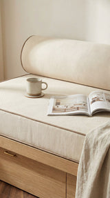 Close-up of a cream daybed cushion and bolster with a mug