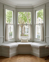 Gray cushions on a white bay window seat