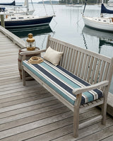 Navy striped cushion on a teak bench on a marina dock