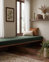 Forest green boucle cushion on a walnut window bench
