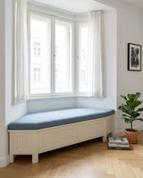 Blue boucle cushion with an angled end on a white bay window seat