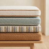 Stacked cushions in cream, sage, stripe and camel boucle