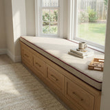 Cream trapezoid cushion with red piping on an oak window bench