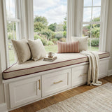 Beige trapezoid cushion with brown piping on a white bay window seat