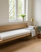 Cream boucle cushion on an oak bench with a backrest