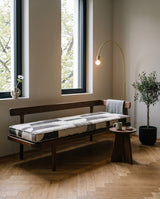 Geometric cushion on a dark wood bench with a backrest