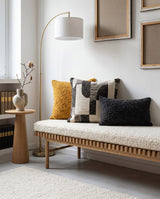 Cream boucle cushion with pillows on a slatted oak bench