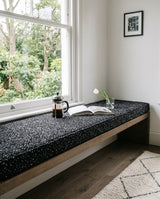 Black speckled cushion on a floating window bench