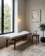 Striped cushion on a dark wood bench with a throw